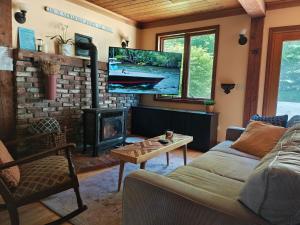 a living room with a fireplace and a tv at Authentic VT Chalet, Hot tub, Fire pit, Mt Snow in Dover