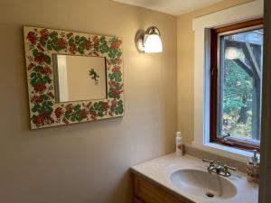 a bathroom with a sink and a mirror on the wall at Authentic VT Chalet, Hot tub, Fire pit, Mt Snow in Dover +48 photos