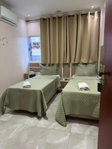a room with two beds and a window at Hotel Prime Tatuapé - Próximo ao Metrô Belém - Café da Manhã Incluso e Estacionamento Econômico no Local in São Paulo +43 photos