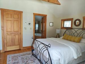 a bedroom with a large bed and a wooden floor at Authentic VT Chalet, Hot tub, Fire pit, Mt Snow in Dover