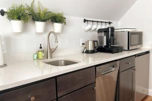 a kitchen counter with a sink and a microwave at 2BR Suite - Bright - Modern - Central AC - Parking in Arlington