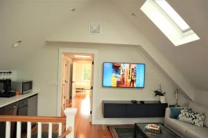 a living room with a couch and a tv on the wall at 2BR Suite - Bright - Modern - Central AC - Parking in Arlington