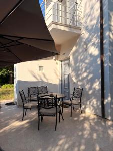 a patio with a table and chairs and an umbrella at Forte dei marmi casa vacanza in Forte dei Marmi