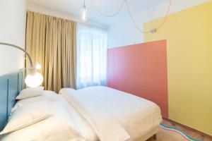 a bedroom with a white bed and a red wall at WanaBark Hotel - The Ultimate Dogs-friendly Spot in Bratislava in Bratislava +3 photos
