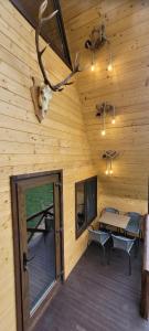 eine Hütte mit Holzdecke, einem Tisch und einem Geweih in der Unterkunft Cabanuta Lunca in Lunca