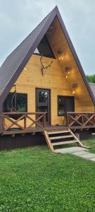 ein Haus mit einem großen Mansarddach und einer Veranda in der Unterkunft Cabanuta Lunca in Lunca + 23 Fotos