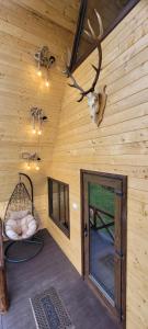 eine Blockhütte mit einem Zimmer mit Tür und Geweih in der Unterkunft Cabanuta Lunca in Lunca