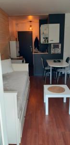 a bedroom with a bed and a table and a kitchen at Studio pistes La Bresse Hohneck in La Bresse