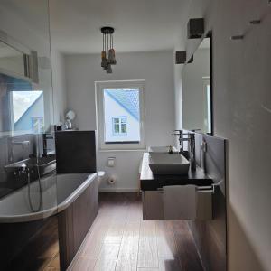a bathroom with a sink and a large mirror at Villa Eckhart in Göhren +10 photos