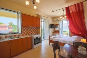 a kitchen with a bedroom and a bed and a table at Remenata in Lixouri