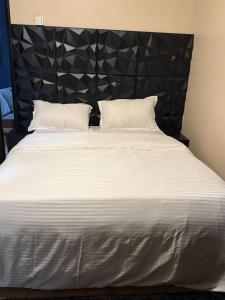 a white bed with two pillows and a black headboard at LILY'S spa and accomodations in Mukono