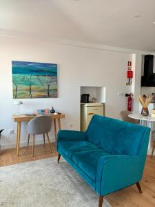a living room with a blue couch and a table at Sobrado das Marias in Figueiró dos Vinhos