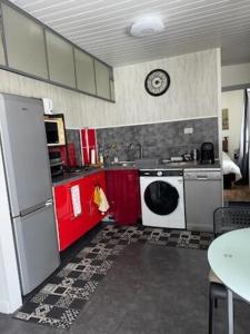 a kitchen with red and white cabinets and a washer at ASM rugby in Cébazat
