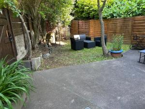 a patio with couches in a backyard with a fence at ASM rugby in Cébazat