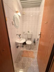 a small bathroom with a toilet and a sink at Sofi Central Apartment in Ohrid