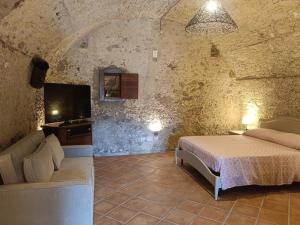a bedroom with a bed and a tv and a couch at Residenza La Vigna in Parghelia +75 photos