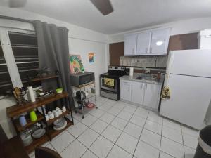 a kitchen with a white refrigerator and a stove at Above The Plaza 4 (6 guest) in Rincon