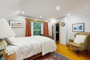 a bedroom with a bed and a chair and a window at 2-story apartment steps from the harbor & downtown in Boothbay Harbor