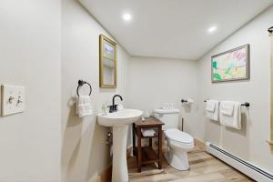 a white bathroom with a sink and a toilet at 2-story apartment steps from the harbor & downtown in Boothbay Harbor +17 photos