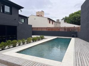 a swimming pool in the backyard of a house at Stream Suites Pinamar in Ostende