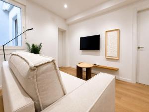 a living room with a couch and a tv at YBH Ocean Boutique in Vigo +4 photos