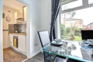 a dining room with a glass table and a window at Kingspark Apartment Apartment in Glasgow +6 photos