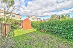 a house with a red shed in a yard at Kingspark Apartment Apartment in Glasgow