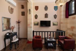a living room with a couch and a tv on the wall at Grand Master Suite in Rhodes Town