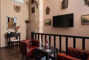 a living room with a couch and a tv on the wall at Grand Master Suite in Rhodes Town