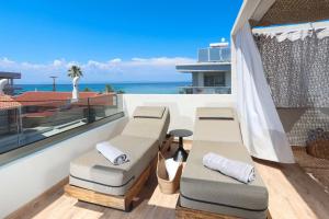 a balcony with lounge chairs and a view of the ocean at D&C Premium Suites in Pefkochori