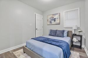 a bedroom with a bed with blue sheets and a window at Cozy 4BR 2BA Worth Home in Worth