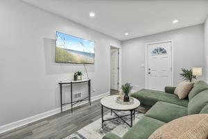 a living room with a green couch and a tv at Cozy 4BR 2BA Worth Home in Worth