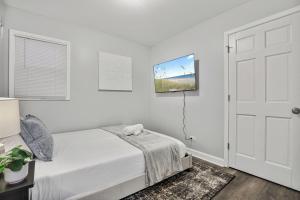 a white bedroom with a bed and a door at Cozy 4BR 2BA Worth Home in Worth