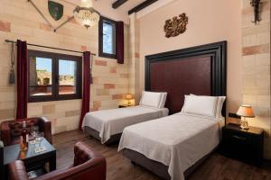 a bedroom with two beds and a couch and a chair at Grand Master Suite in Rhodes Town