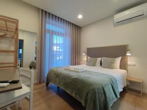 a bedroom with a large bed and a desk at Barcelos Habadia da Loja in Lijó
