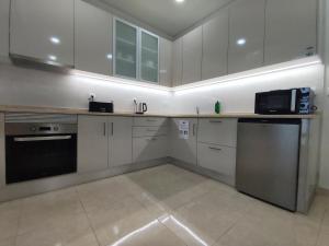 a kitchen with white cabinets and a microwave at Barcelos Habadia da Loja in Lijó