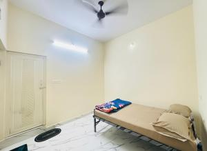 a bedroom with a bed and a ceiling fan at Forum Stay in Mysore