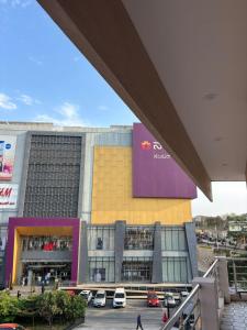 a large building with cars parked in a parking lot at Forum Stay in Mysore