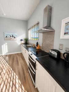 a kitchen with a sink and a stove top oven at Dunmore East Ocean View Suite in Dunmore East