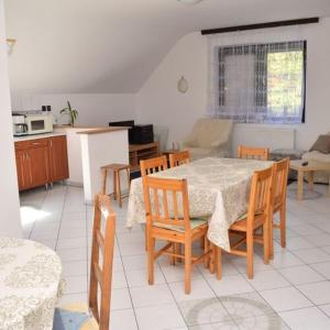 a kitchen and dining room with a table and chairs at Andrea Apartman in Siófok