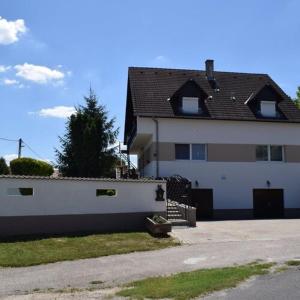 a large white house with a fence next to it at Andrea Apartman in Siófok