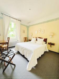 a bedroom with a bed and a desk and a window at Le Relais Notre Dame in Quinson +53 photos
