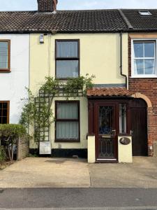 a house with a brown door and a building at Stay at 48 in Oulton