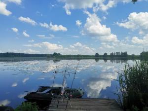 a boat sitting on a dock on a lake at Haromfa Apartman in Háromfa