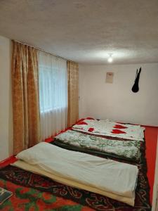 a bedroom with two beds and a window at Чырак in Ak-Osten