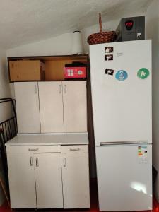 a kitchen with white cabinets and a refrigerator at Чырак in Ak-Osten
