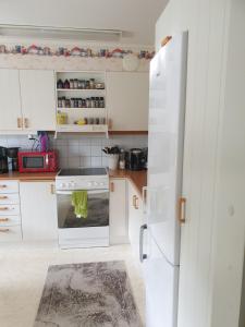 a kitchen with white cabinets and a white stove top oven at Lägenhet in Köpingsvik