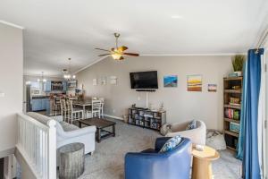 a living room with a couch and a tv at Escape OBX in Kitty Hawk