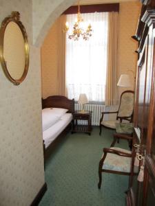 a bedroom with a bed and a mirror and a chair at Hotel Stephan in Hamburg
