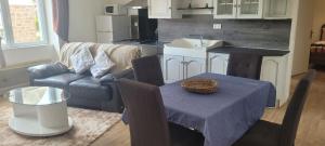 a living room with a couch a table and a kitchen at Appartement 2 Ch la Romagne in La Romagne